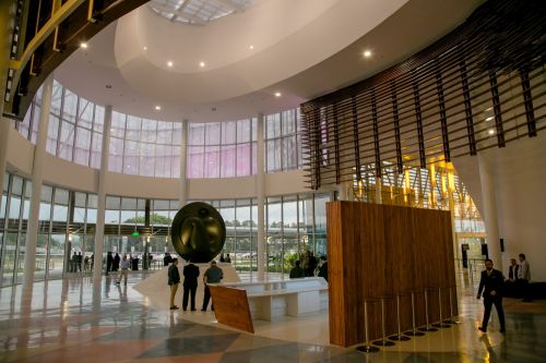 Grand lobby with Deredia sculpture, geometric floor, and natural light.
