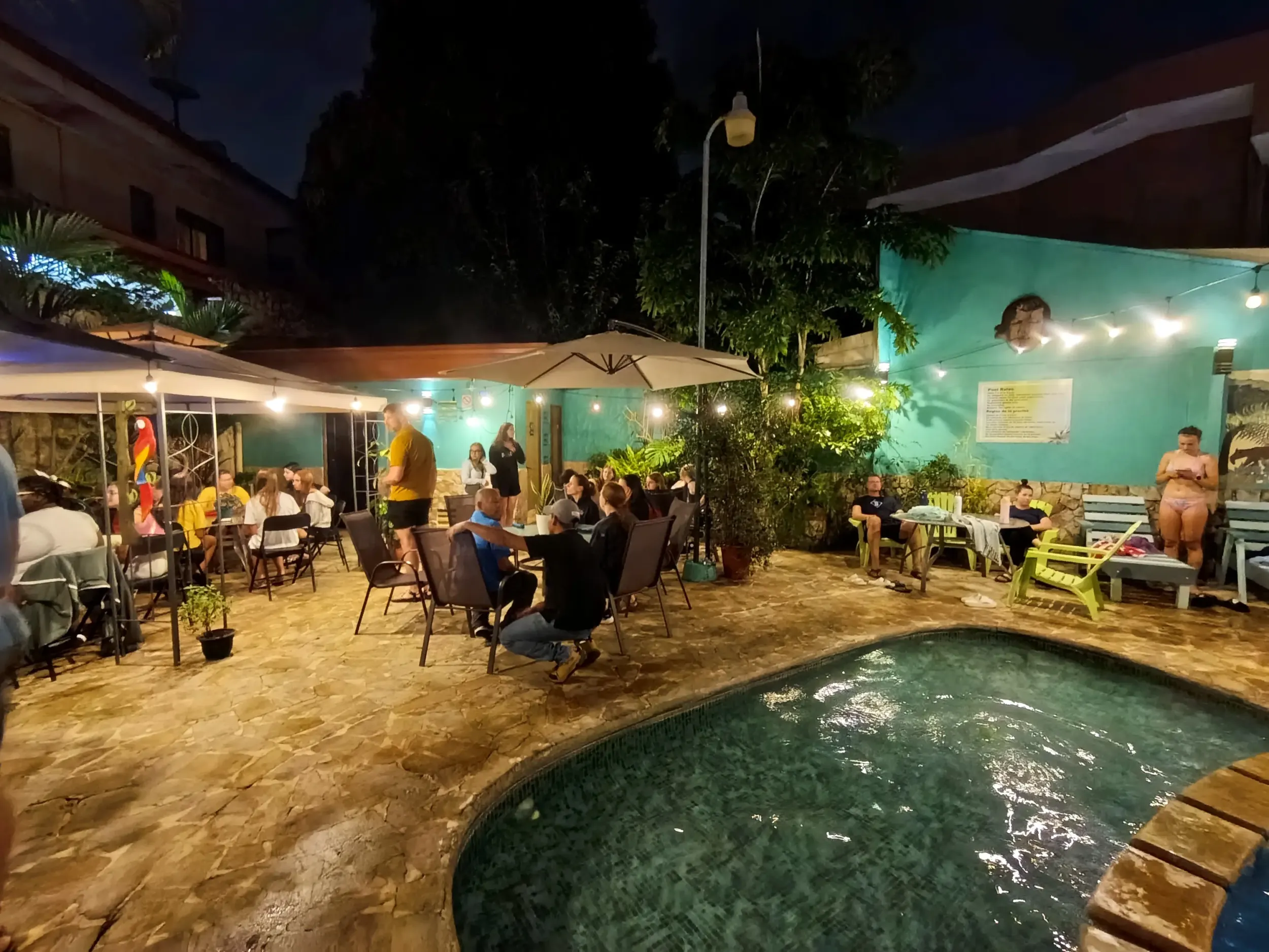 Guests socializing in the pool courtyard on a warm evening