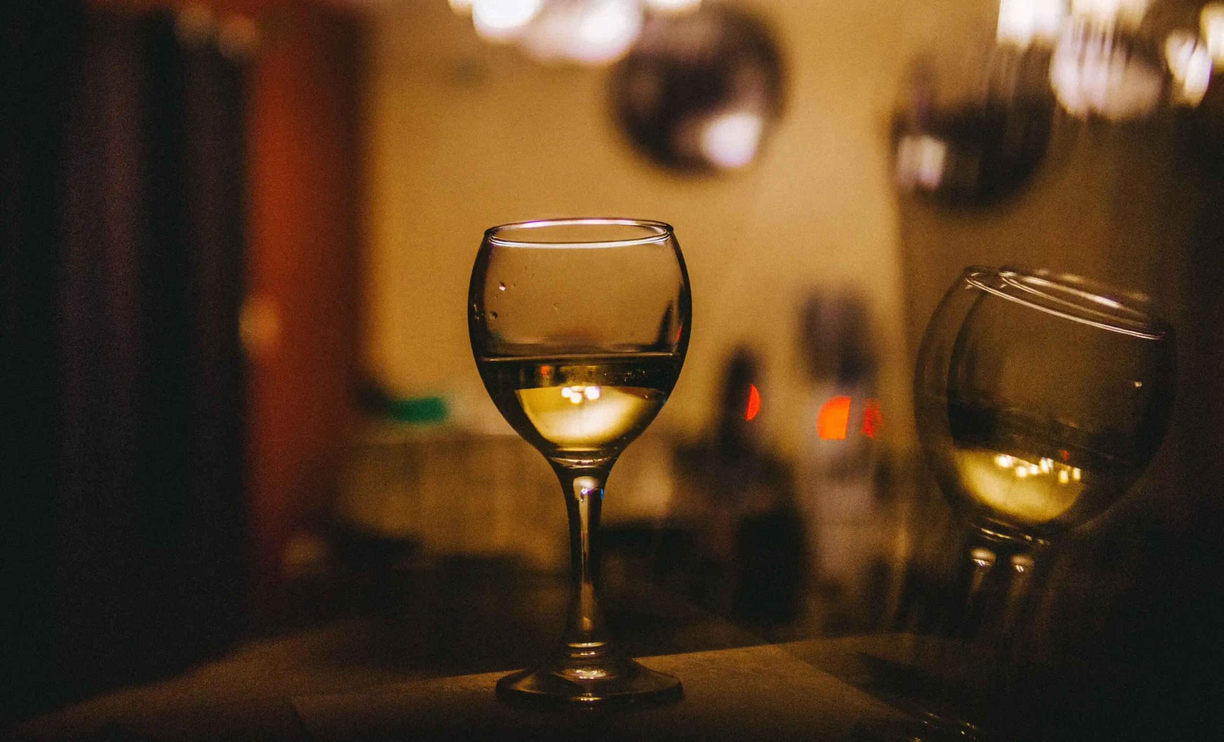 Glass of white wine in a warm restaurant setting.