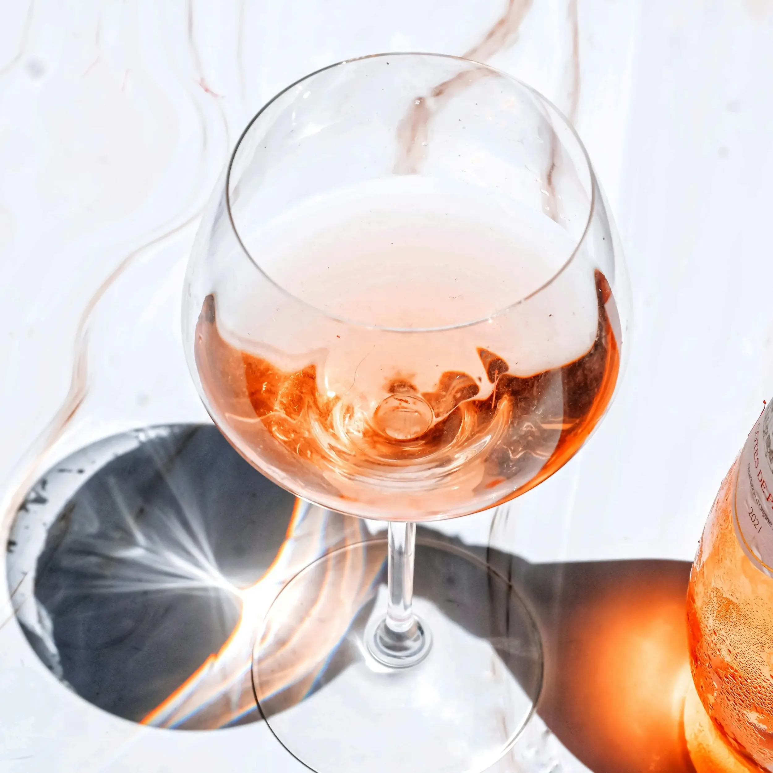 Glass of rose wine on a light marble surface.