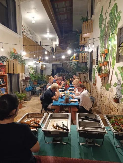 Group sharing a communal meal in the tropical courtyard.