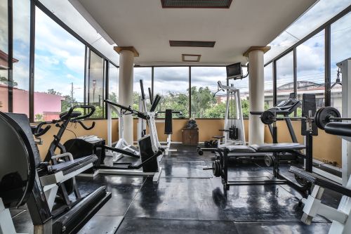Fitness center with cardio and weight equipment and neighborhood views.