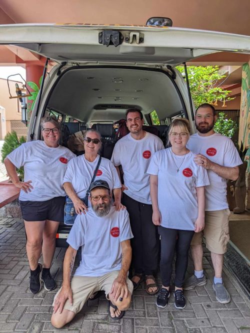 Group ready for departure at Adventure Inn — airport transfer van